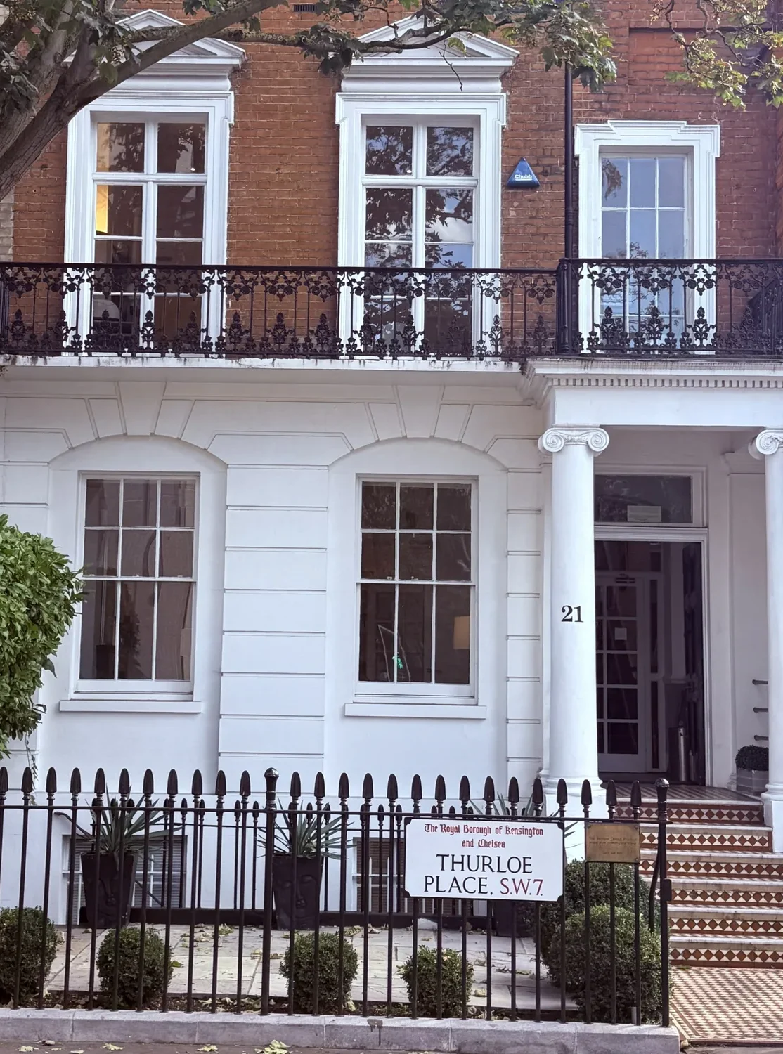 The front of Behrens Dental Practice at 21 Thurloe Place, South Kensington, London SW7, with the Royal Borough of Kensington and Chelsea street sign on the railings